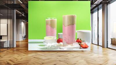 Natural healthy summer drink. Diet organic strawberry and matcha latte cocktail, with fresh strawberry and ice, on a white light green background Wall mural