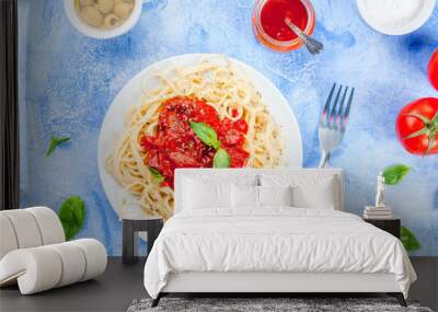 Spaghetti with tomato sauce, olives, tomato and basil on a light blue stone concrete table top view copy space Wall mural