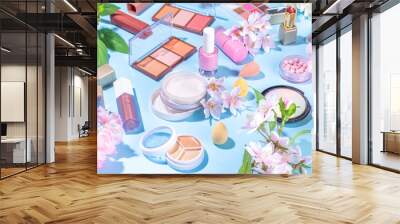 Spring make up set on light blue background. Different make-up professional cosmetics, beauty accessories flat lay with spring blossom flowers top view copy space Wall mural