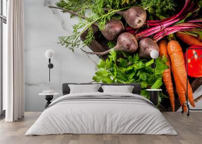 Summer, autumn harvest. Fresh organic farm vegetables in a wooden box on a white marble table - beets, carrots, parsley, tomatoes. Copy space top view Wall mural