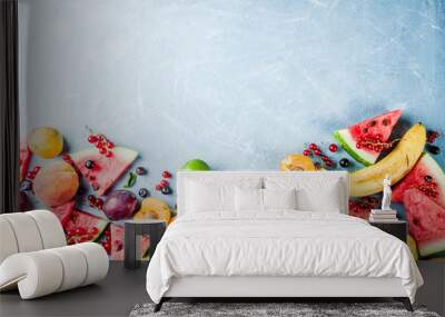 Summer vitamin food concept, various fruit and berries watermelon peach mint plum apricots blueberry currant, creative flat lay on light blue background top view copy space Wall mural