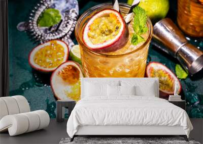 Sweet colorful tropical cocktail with passion fruit, lime and mint. Long boozy alcohol passion fruit drink over dark background copy space Wall mural