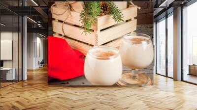 Traditional Christmas alcoholic cocktail - Irish Cream, Cola de mono (monkey tail), decorated with cinnamon. Against the background of Christmas decorations on a wooden table. Copy space  Wall mural