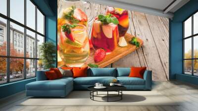 Traditional summer drink sangria - red, pink and white. With champagne, pink and red wine, strawberries, oranges, lemon, green apple and grapefruit. On a wooden rustic table, copy space Wall mural