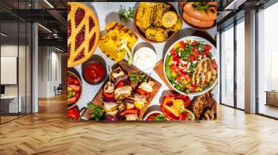 Various picnic barbeque food and drink flatlay. Summer bbq picnic food, assorted grilled meats, kebabs, vegetable, fruit salad, traditional picnic summer pie cake, sandwiches, top view copy space Wall mural