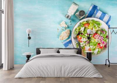 Vegan and vegetarian summer food background. Vegetable salad, with tomato, lettuce, cheese, fresh green lunch. Healthy eating concept. Light blue background copy space Wall mural