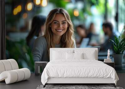 A photo of happy businesswoman in an office, using laptops and discussing work with each other.  Wall mural