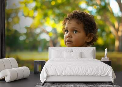 portrait of cute australian indigenous child in park wearing yellow tshirt Wall mural