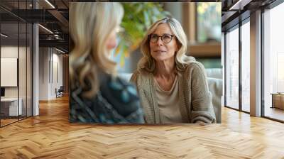 Therapy Session: Woman in Her Late Thirties Talking to Older Female Therapist with Blonde Hair on Couch, Stock Photo, Professional Photography, Light Gray Palette Wall mural