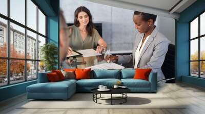 African businesswoman signing document during meeting Wall mural