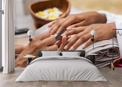 Beautician file nails to a black hand Wall mural