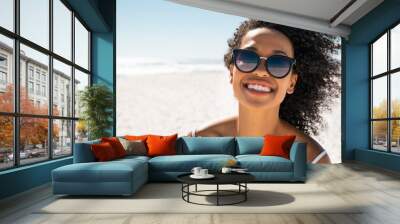 Beautiful black woman at beach wearing sunglasses Wall mural