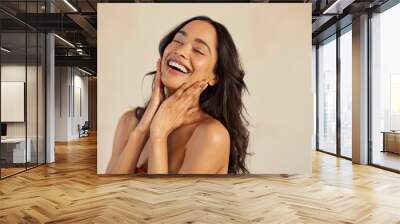 Beautiful laughing woman touching her skin with joy Wall mural