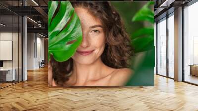 Beauty natural woman covering her face with tropical leaf Wall mural