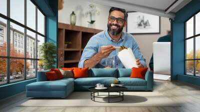 Businessman eating noodles during lunch break Wall mural