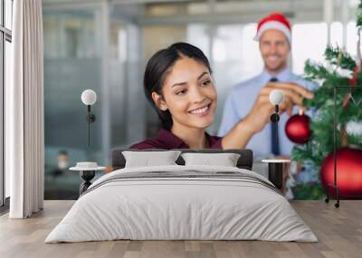 Businesswoman decorating christmas tree at office Wall mural