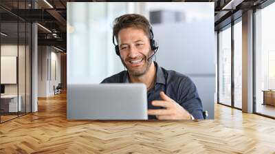 Cheerful mid adult man having video call on laptop Wall mural