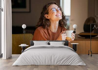 cheerful woman enjoying coffee cup in a winter afternoon Wall mural