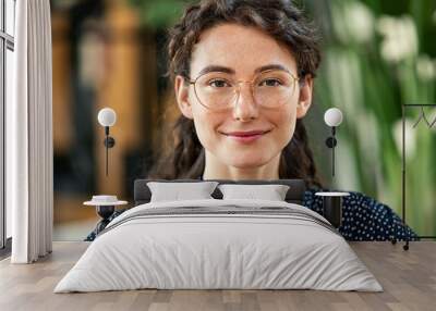 Close up face of confident young woman wearing spectacles and looking at camera Wall mural