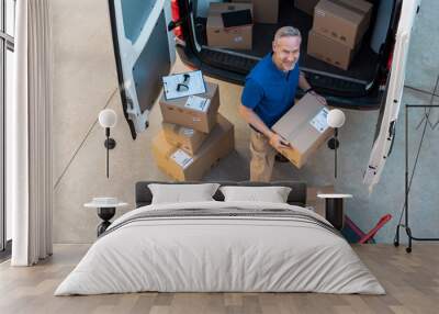 Delivery man unloading parcel Wall mural