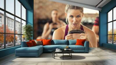 Determined fitness woman doing squat with kettle bell Wall mural