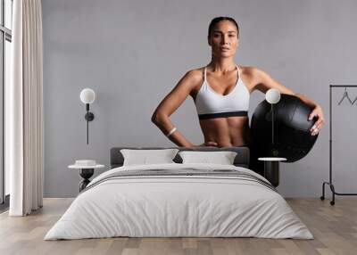 Determined fitness woman on grey background Wall mural