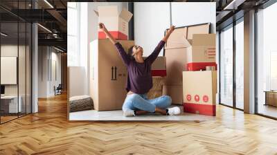 Excited young woman in new house Wall mural