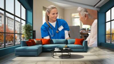 Friendly nurse talking with old couple Wall mural