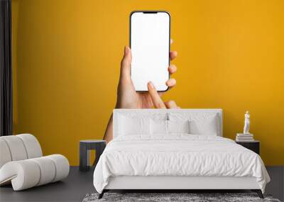 Hands using smartphone on orange background Wall mural