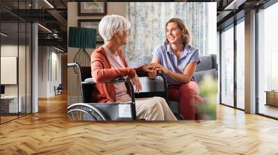 Happy adult woman visiting her elderly mother at home Wall mural