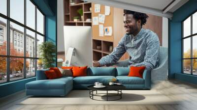 Happy african businessman using computer Wall mural