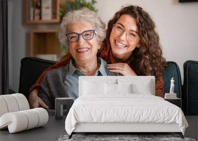 Happy grandmother with smiling granddaughter at home Wall mural