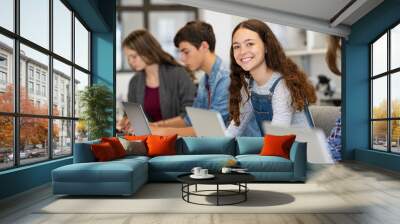 Happy high school girl using laptop in classroom Wall mural