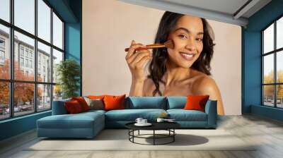 Happy latin beauty woman applying makeup powder Wall mural