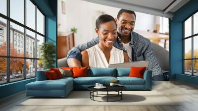 Happy mature african american couple using digital tablet at home Wall mural