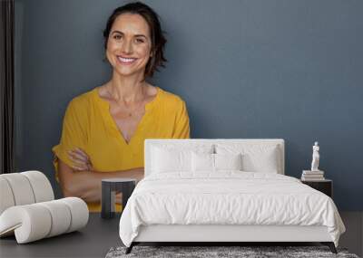 Happy mature woman smiling on grey wall Wall mural