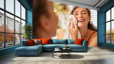 Happy woman wiping face with towel in bathroom Wall mural