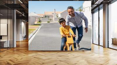 Indian father helping son riding bike outdoor Wall mural