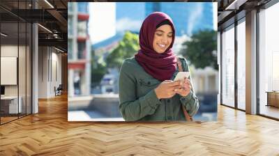 Islamic woman in hijab using phone Wall mural