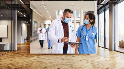 Mature doctor and nurse discussing patient case Wall mural