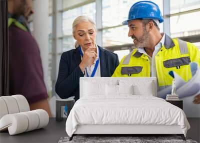 Mature engineer and contractor woman discussing at construction site Wall mural