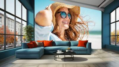 Mature woman with beach hat and sunglasses Wall mural