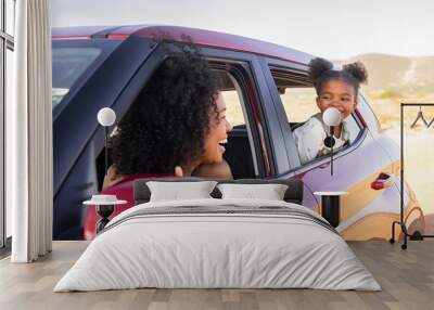 Mother and black daughter peeping outside car Wall mural