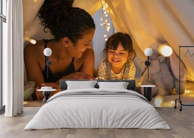 Mother and daughter playing at home in tent Wall mural