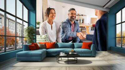 Multiethnic couple handshake with consultant at home Wall mural