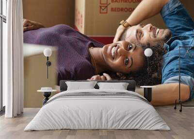 Multiethnic couple lying on floor after moving house Wall mural