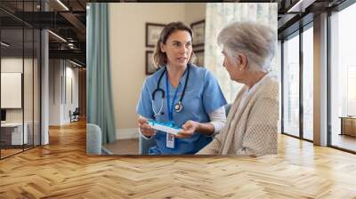 Nurse explaining medicine dosage to senior woman at nursing home Wall mural