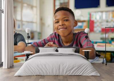 Portrait of african american child sitting at desk at elemetary school Wall mural