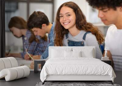 Portrait of happy high school girl studying in class Wall mural