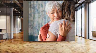 Senior woman embracing daughter after covid immunization vaccine Wall mural